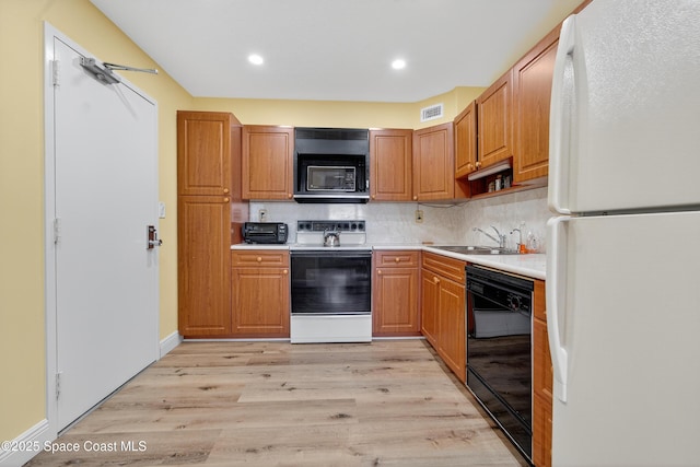10777 W Sample Rd Unit 1212, Coral Springs, FL 33067 - kitchen featuring black appliances, light wood-style flooring, light countertops, tasteful backsplash, and recessed lighting