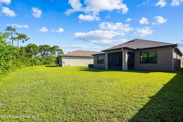 820 Old Country Rd SE, Palm Bay, FL 32909 - back of house featuring a yard, stucco siding, and a sunroom