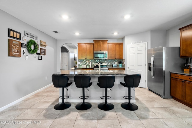 820 Old Country Rd SE, Palm Bay, FL 32909 - kitchen with stainless steel appliances, arched walkways, backsplash, dark stone counters, and recessed lighting