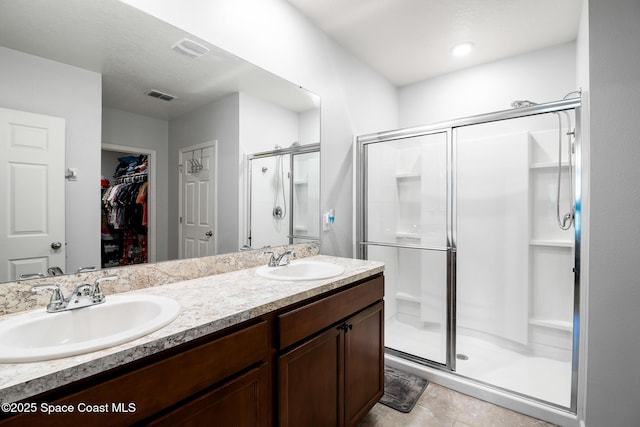 820 Old Country Rd SE, Palm Bay, FL 32909 - bathroom with a stall shower, double vanity, a spacious closet, and tile patterned flooring