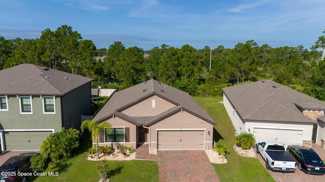 820 Old Country Rd SE, Palm Bay, FL 32909 - view of front facade with stucco siding, a front yard, driveway, a garage, and roof with shingles