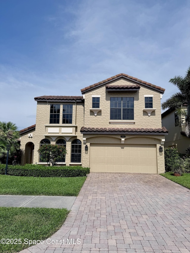 659 Monterey Dr, Satellite Beach, FL 32937 - mediterranean / spanish house with an attached garage, decorative driveway, and stucco siding