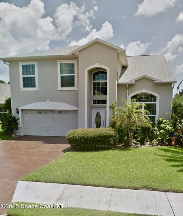 968 Shaw Cir, Melbourne, FL 32940 - view of front of house with stucco siding, a front yard, an attached garage, and driveway