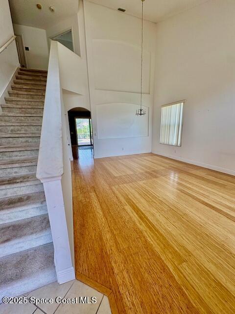 968 Shaw Cir, Melbourne, FL 32940 - stairway with a high ceiling, arched walkways, and wood finished floors