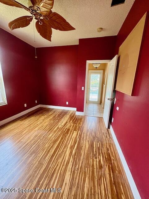 968 Shaw Cir, Melbourne, FL 32940 - empty room with wood finished floors, a textured ceiling, ceiling fan, and a smoke detector