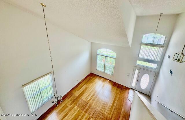 968 Shaw Cir, Melbourne, FL 32940 - foyer entrance featuring high vaulted ceiling, a textured ceiling, and wood finished floors