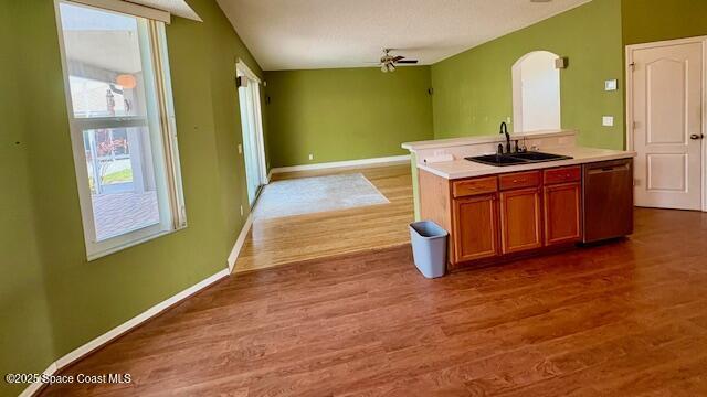 968 Shaw Cir, Melbourne, FL 32940 - kitchen featuring dishwasher, wood finished floors, arched walkways, ceiling fan, and light countertops