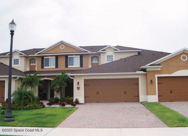 5720 Claiborne St, Melbourne, FL 32940 - traditional home with decorative driveway, stucco siding, a front yard, and a garage