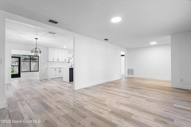 4890 Yew Ct, Titusville, FL 32796 - unfurnished living room featuring light wood-style floors, a chandelier, and recessed lighting