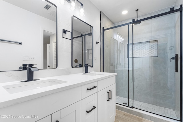 4890 Yew Ct, Titusville, FL 32796 - bathroom with double vanity, a shower stall, wood finished floors, and recessed lighting