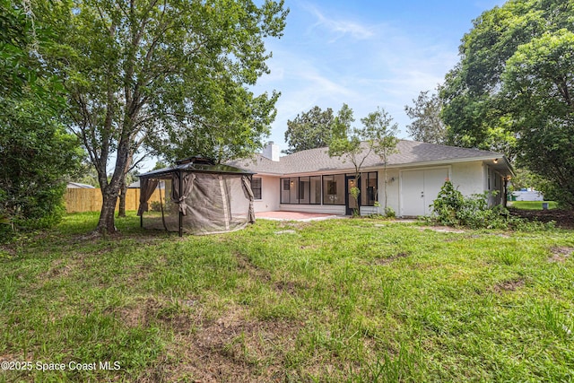 4890 Yew Ct, Titusville, FL 32796 - rear view of house featuring a chimney, a patio area, stucco siding, and a sunroom