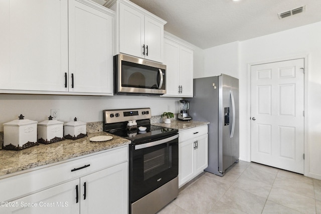 1669 Mineral Loop Dr NW, Palm Bay, FL 32907 - kitchen with appliances with stainless steel finishes, white cabinets, light stone countertops, and light tile patterned flooring