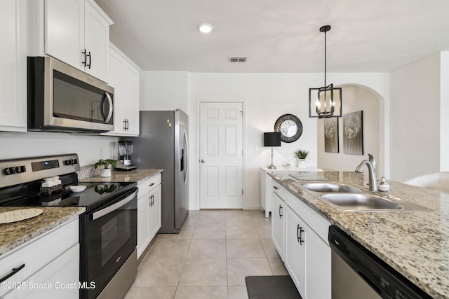 1669 Mineral Loop Dr NW, Palm Bay, FL 32907 - kitchen with stainless steel appliances, white cabinets, light tile patterned flooring, pendant lighting, and light stone counters
