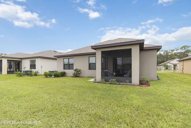 1669 Mineral Loop Dr NW, Palm Bay, FL 32907 - back of property featuring stucco siding, a sunroom, and a lawn