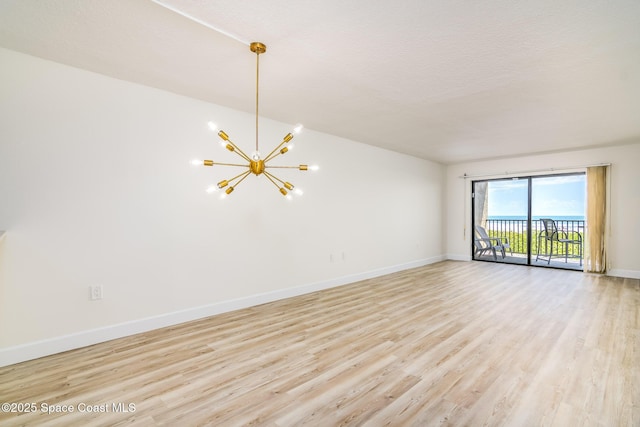 8496 Ridgewood Ave Unit 3205, Cape Canaveral, FL 32920 - unfurnished room with a chandelier and light wood-type flooring
