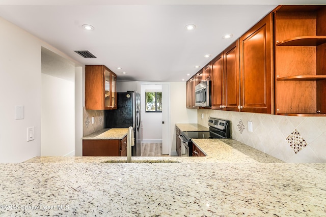 8496 Ridgewood Ave Unit 3205, Cape Canaveral, FL 32920 - kitchen featuring appliances with stainless steel finishes, open shelves, decorative backsplash, light stone counters, and recessed lighting