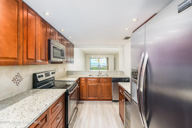 8496 Ridgewood Ave Unit 3205, Cape Canaveral, FL 32920 - kitchen featuring stainless steel appliances, light wood-type flooring, decorative backsplash, light stone counters, and recessed lighting
