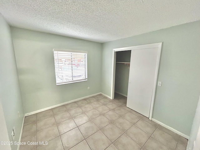 176 San Juan Cir, Melbourne, FL 32935 - unfurnished bedroom featuring a textured ceiling, a closet, and light tile patterned floors