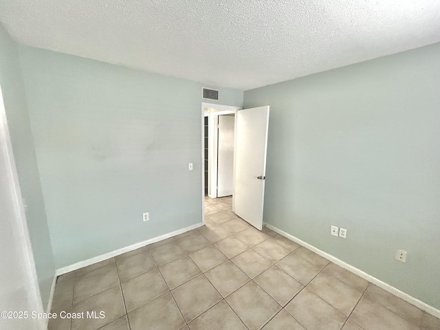 176 San Juan Cir, Melbourne, FL 32935 - unfurnished room featuring a textured ceiling and light tile patterned flooring