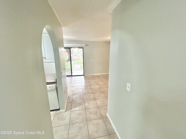 176 San Juan Cir, Melbourne, FL 32935 - hallway featuring light tile patterned floors, arched walkways, and a textured ceiling