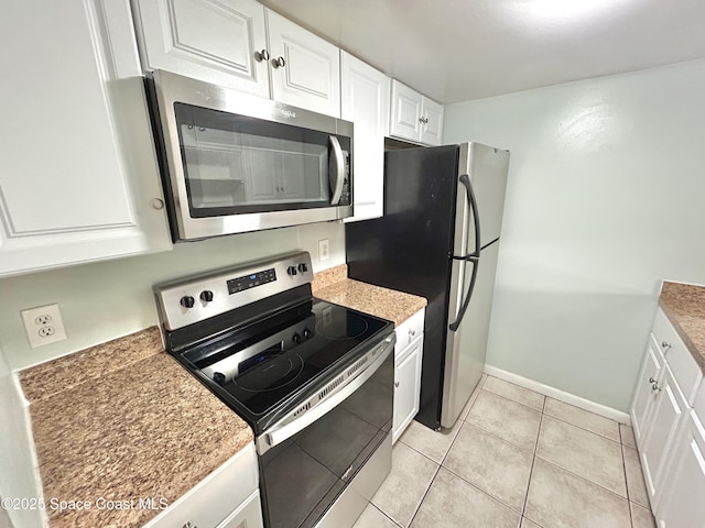 176 San Juan Cir, Melbourne, FL 32935 - kitchen with appliances with stainless steel finishes, white cabinets, and light tile patterned floors