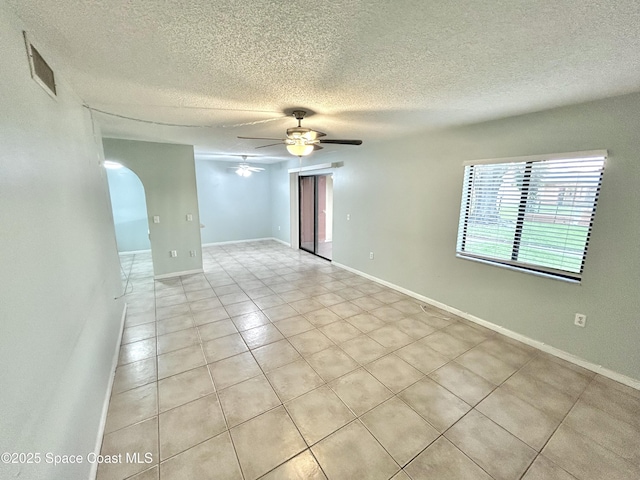 176 San Juan Cir, Melbourne, FL 32935 - empty room with ceiling fan, arched walkways, light tile patterned flooring, and a textured ceiling