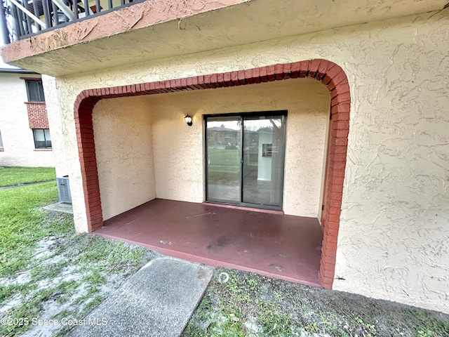 176 San Juan Cir, Melbourne, FL 32935 - doorway to property with stucco siding, a balcony, and a patio