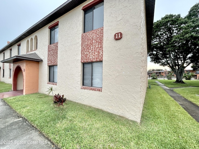 176 San Juan Cir, Melbourne, FL 32935 - view of home's exterior featuring stucco siding and a lawn