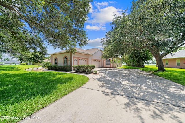 3912 Snowy Egret Dr, Melbourne, FL 32904 - view of front of house with stucco siding, driveway, a front lawn, and an attached garage