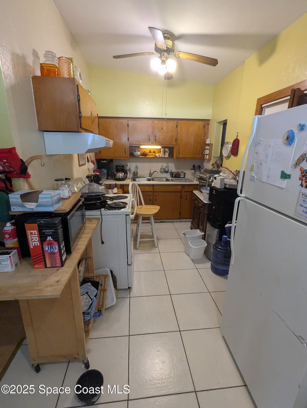 213 Lagrange Ave, Titusville, FL 32796 - kitchen featuring white appliances, brown cabinets, light countertops, ceiling fan, and exhaust hood