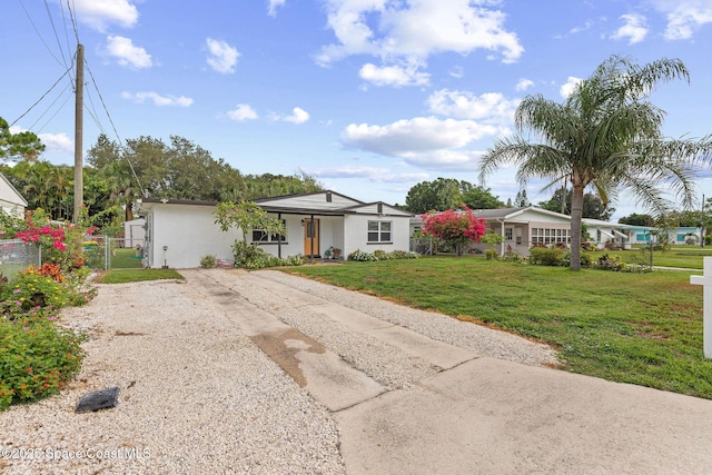 312 Tulip Ln, Melbourne, FL 32901 - ranch-style house with gravel driveway, a gate, and stucco siding