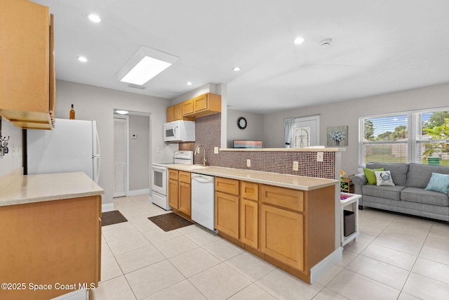 312 Tulip Ln, Melbourne, FL 32901 - kitchen featuring a peninsula, backsplash, white appliances, light countertops, and recessed lighting