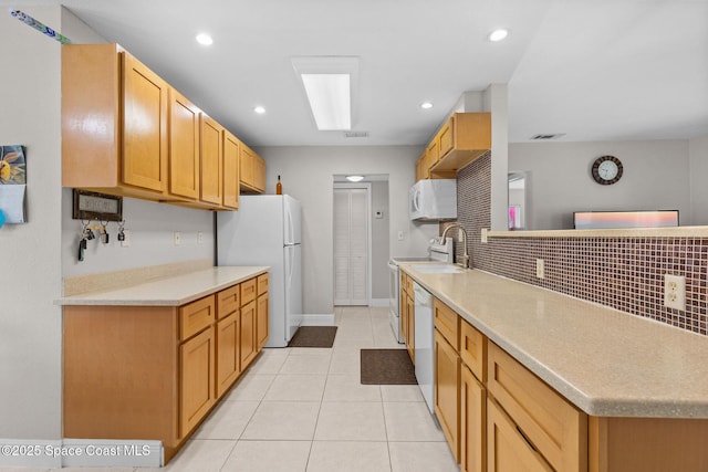 312 Tulip Ln, Melbourne, FL 32901 - kitchen featuring white appliances, light countertops, light tile patterned floors, tasteful backsplash, and recessed lighting