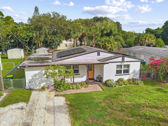 312 Tulip Ln, Melbourne, FL 32901 - view of front of property with a gate, a porch, roof mounted solar panels, and a shed