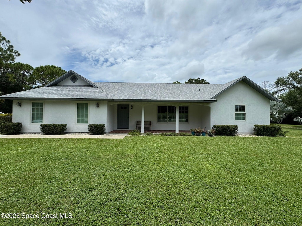 3340 Weber Rd, Malabar, FL 32950 - ranch-style house with stucco siding, a front lawn, a shingled roof, and a porch