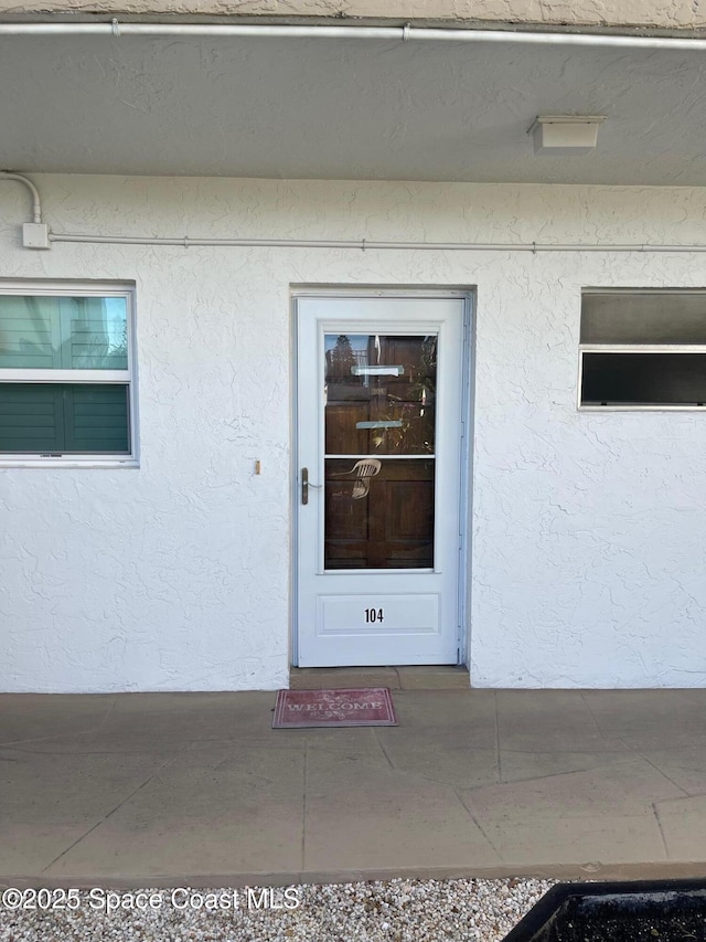 725 Port Malabar Blvd NE, Palm Bay, FL 32905 - doorway to property with stucco siding