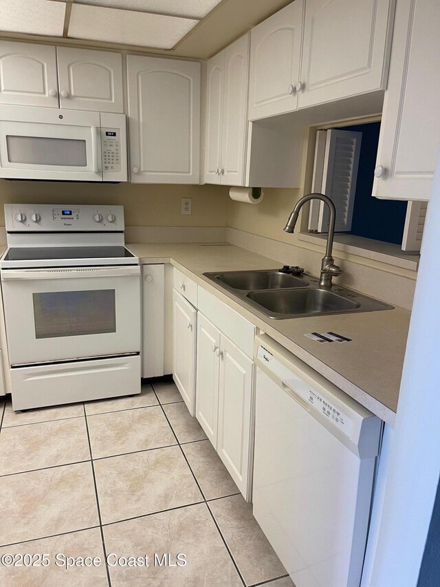 725 Port Malabar Blvd NE, Palm Bay, FL 32905 - kitchen with white appliances, white cabinets, light tile patterned floors, and light countertops