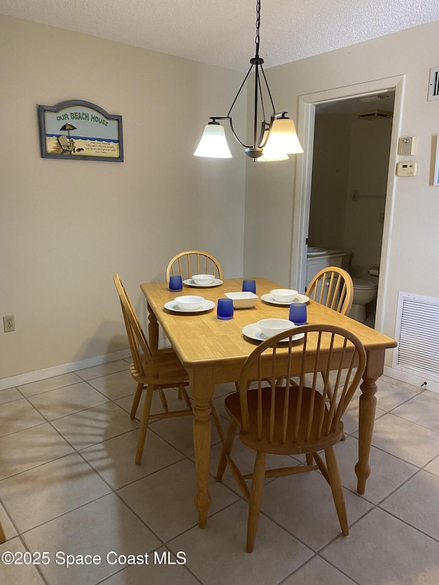 3343 Sandy Reef Ct, Melbourne Beach, FL 32951 - dining room featuring light tile patterned floors and a textured ceiling