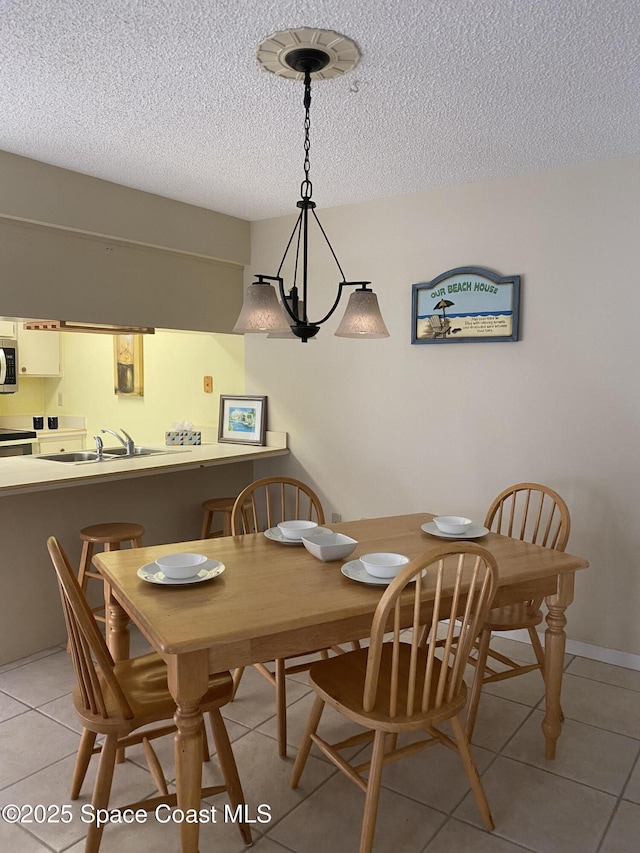 3343 Sandy Reef Ct, Melbourne Beach, FL 32951 - dining room featuring a textured ceiling and light tile patterned flooring