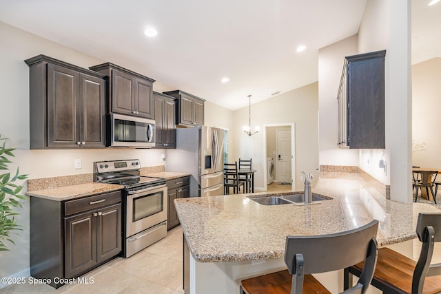 2097 Attilburgh Blvd, Melbourne, FL 32904 - kitchen featuring stainless steel appliances, a peninsula, a breakfast bar, vaulted ceiling, and light stone countertops