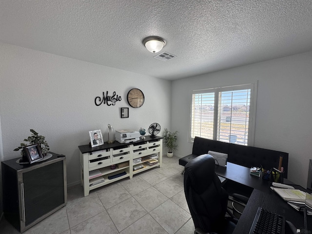 office area with light tile patterned floors, a textured ceiling, and visible vents