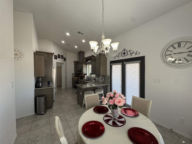 dining room featuring light tile patterned floors, baseboards, visible vents, lofted ceiling, and an inviting chandelier