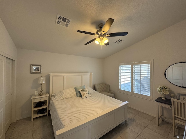 bedroom featuring visible vents, vaulted ceiling, a textured ceiling, and light tile patterned flooring