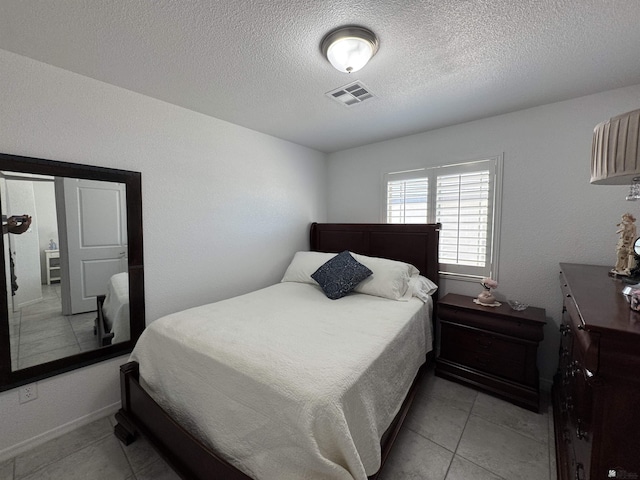 bedroom with a textured ceiling and visible vents