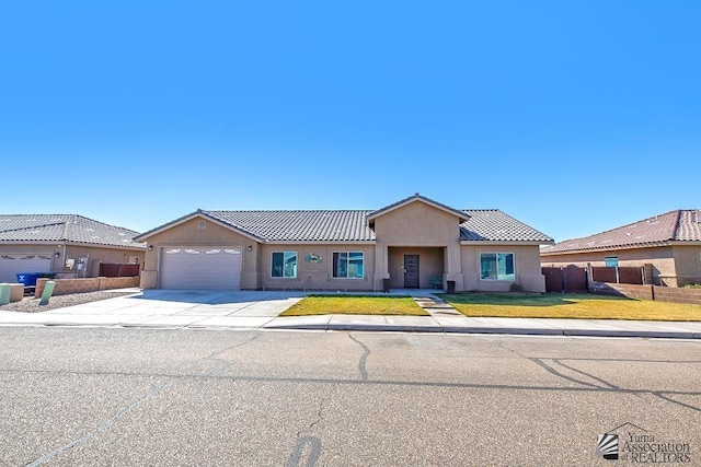 view of front of house featuring stucco siding, concrete driveway, an attached garage, fence, and a front lawn