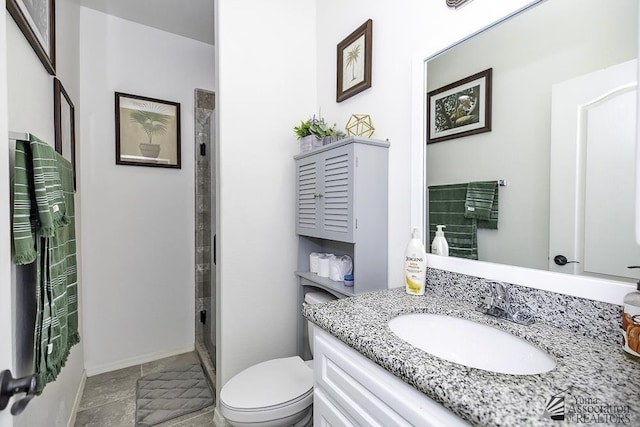 bathroom featuring toilet, a shower, vanity, and baseboards