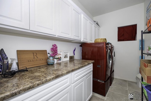 clothes washing area with washer and dryer, cabinet space, and light tile patterned floors