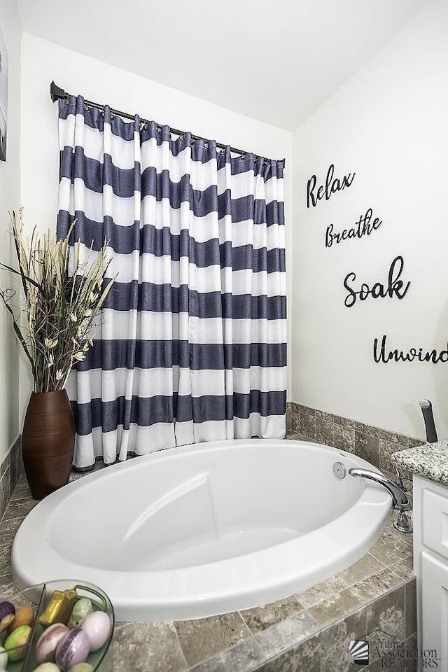 bathroom with tiled bath and vanity