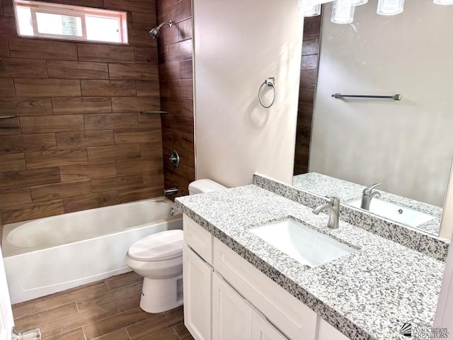 bathroom with tub / shower combination, toilet, vanity, and wood finish floors