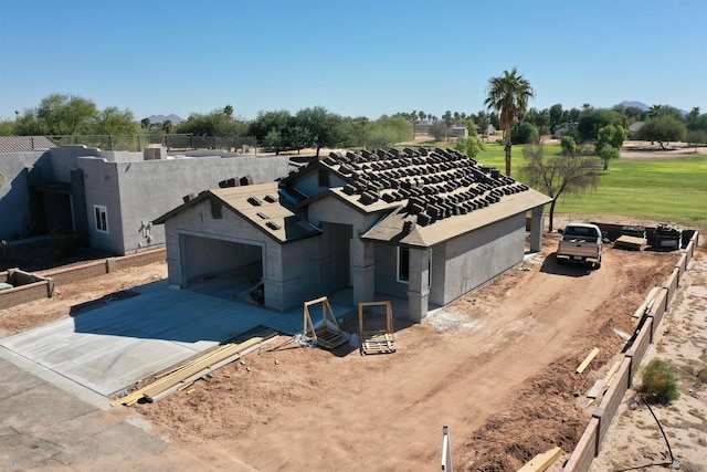 view of front of house with an attached garage, fence, driveway, and stucco siding